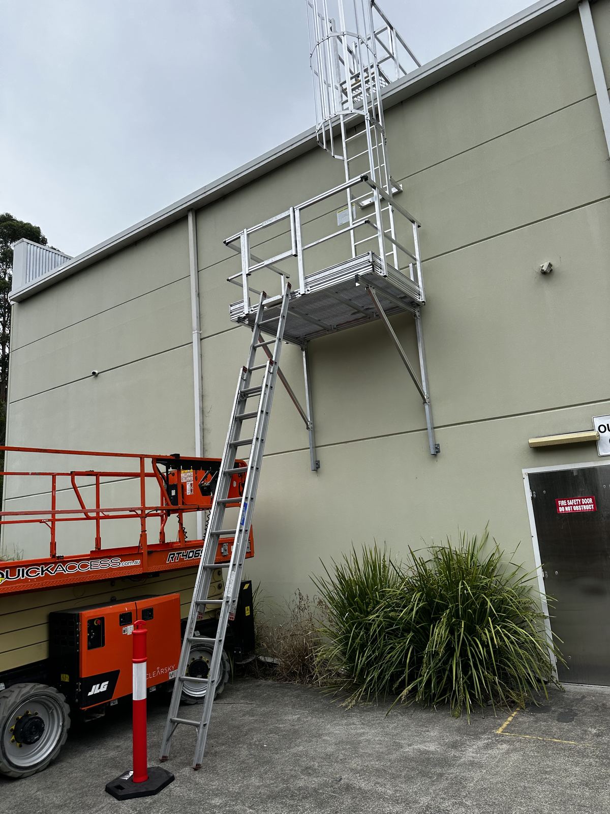 Cantilever platform and caged ladder access system installed on building