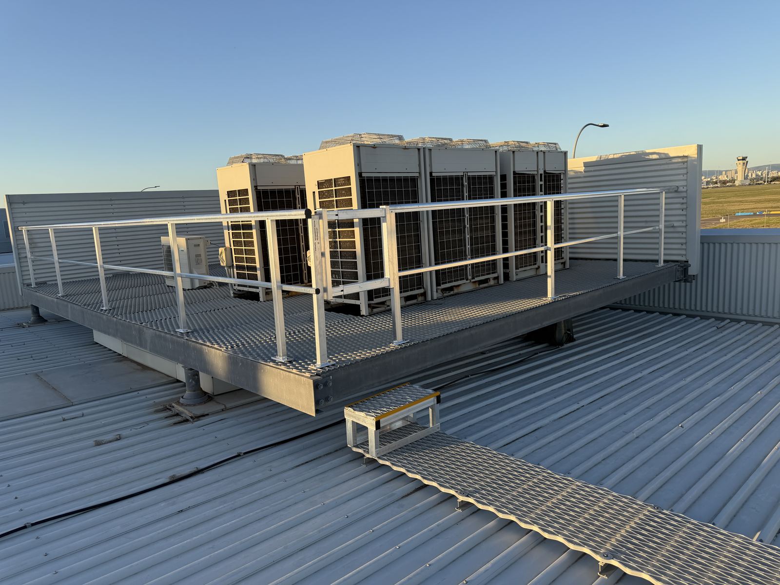 Aluminium guardrail installed on existing rooftop plant platform deck with mini step and self-closing gate