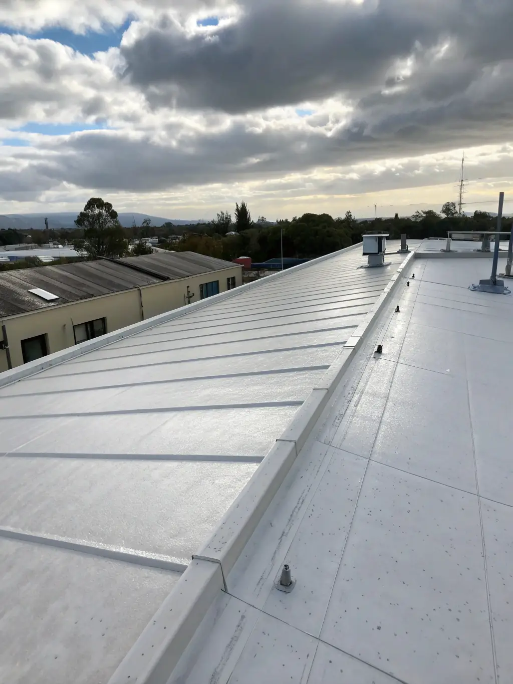 A completed roof safety system installed by Height Safety Compliance Systems is shown on a commercial building, with clear signage and well-maintained equipment.